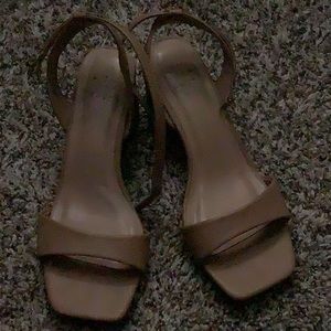 Tan wedged heels, opened toed with a strap, and ankle hook